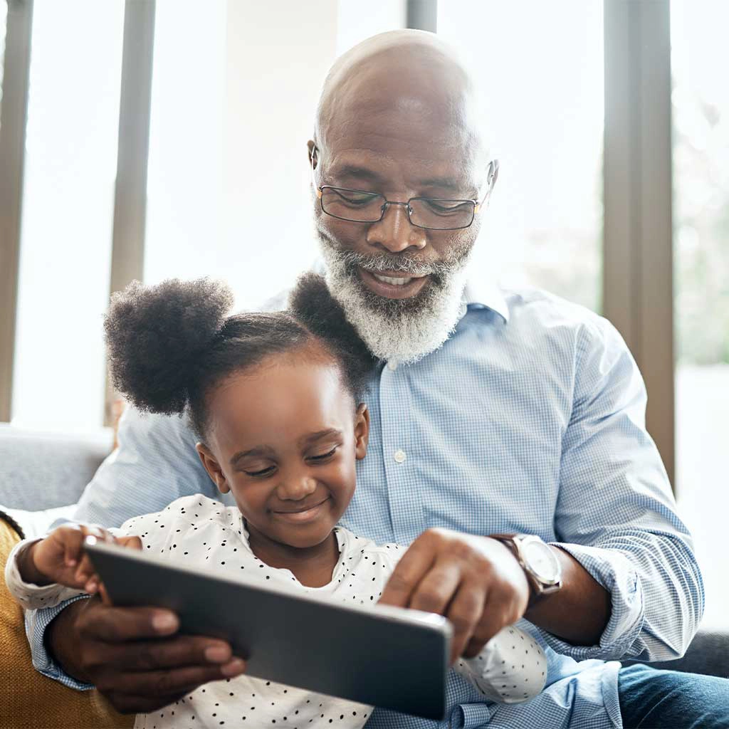 Grandfather and granddaughter looking at a tablet together
